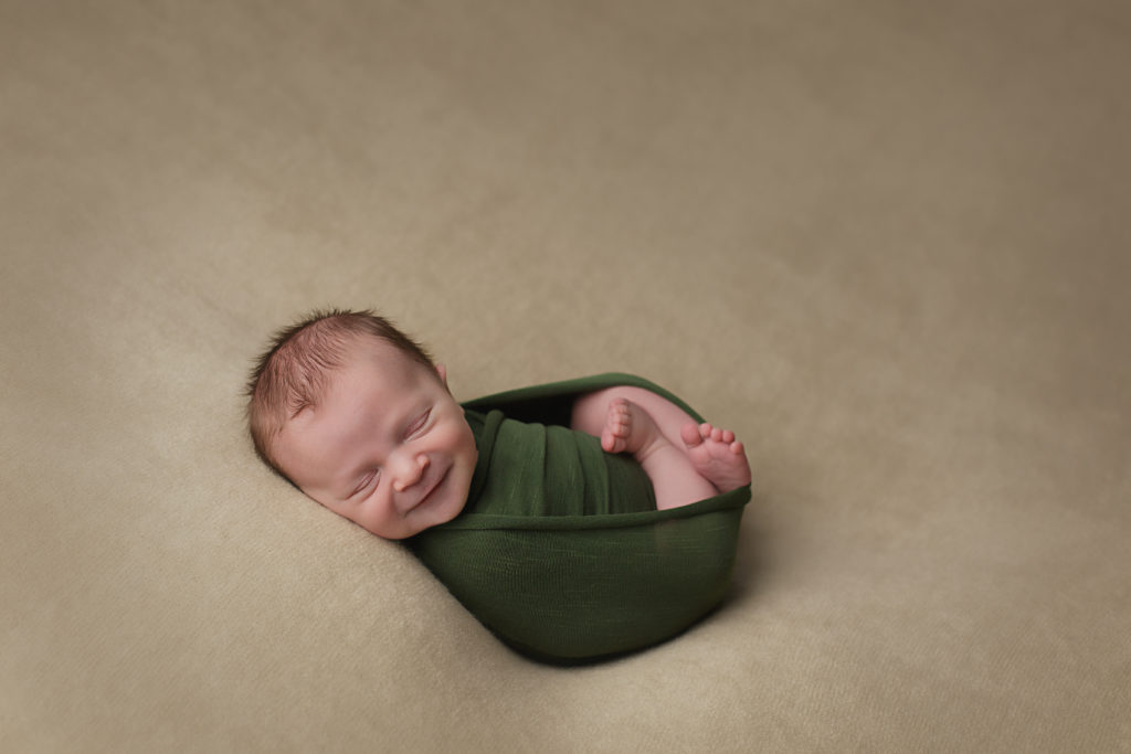 Baby boy giving the photographer a great big smile.